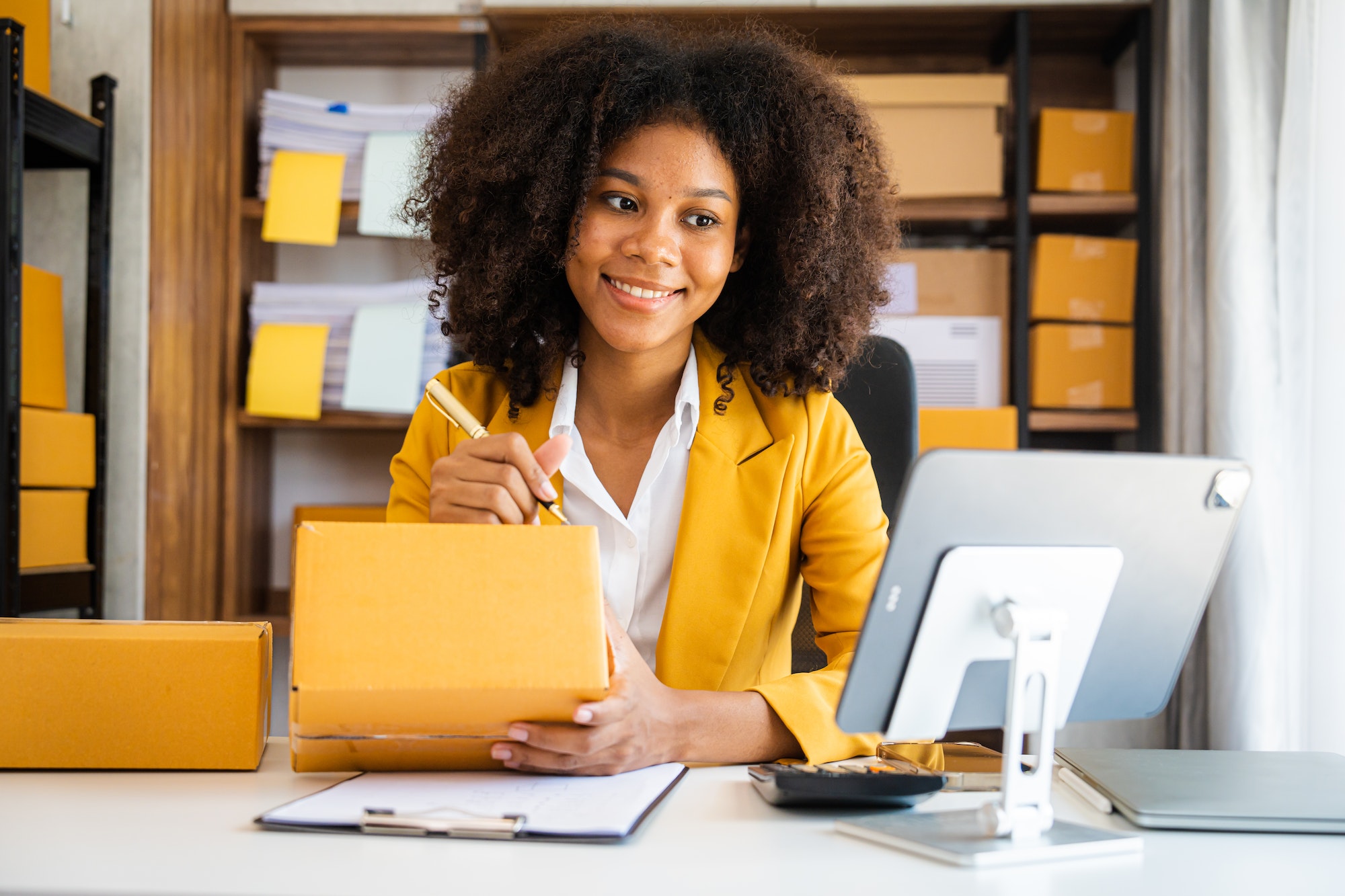 African American business woman working at warehouse preparing SME package box for delivery